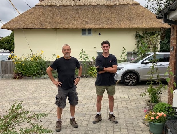 Master thatcher, Glen Charter and his apprentice, Richard Seaman standing proudly in front of their recently completed thatched roof in Newnham