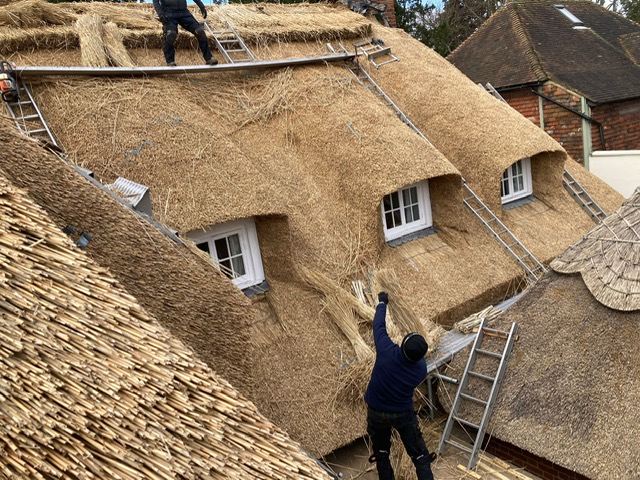 Work underway thatching a roof