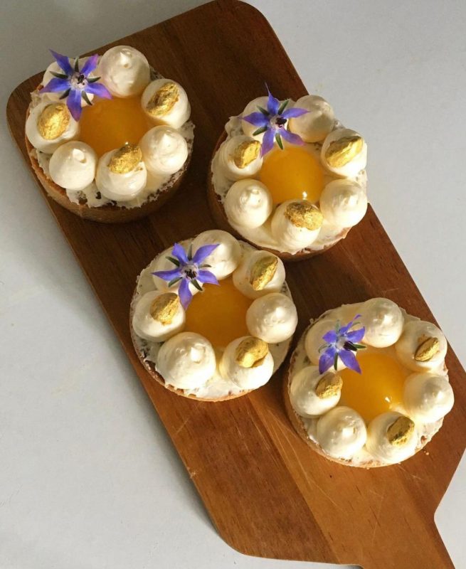Orange-flavoured pastry filled with basbousa and rose creme pat with cardamom Italian buttercream and orange jelly, garnished with borage flowers and pistachios