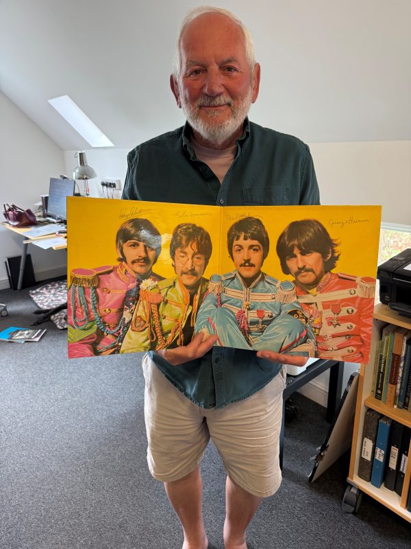 Dr Paul Wilkinson with the Beatles Sergeant Pepper Lonely Hearts Club album for which he did the art work