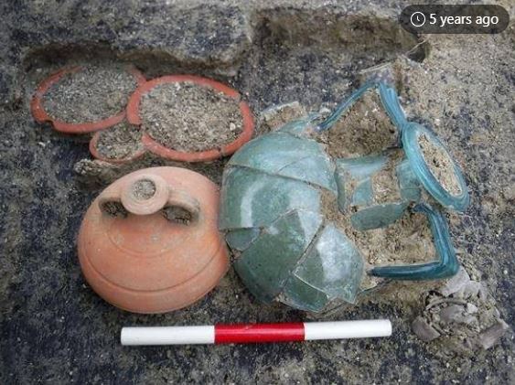 Roman cremation involved burning the body on a funeral pyre just outside the settlement - in this case Charing with ashes and bones after being washed in wine placed in a glass urn which was then interred with food and drink on plates, and a double handled pottery vessel for the final journey to the afterlife dated 2nd century AD.